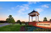 Entrance monument sign and landscaped grounds for Longwood at Oakmont retirement community beneath a blue sky.
