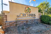 Entrance sign for The Orchards Senior Living with stone base and landscaping.