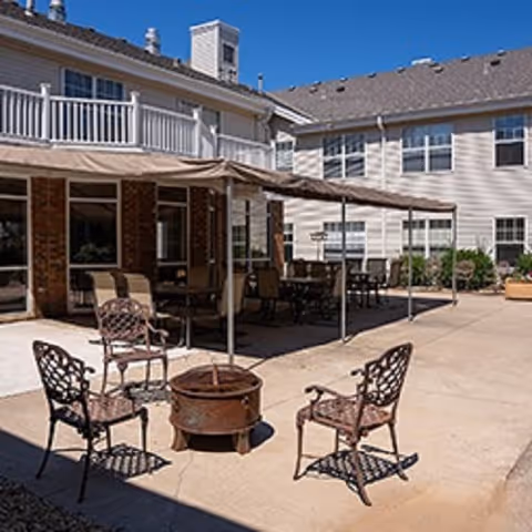 Outdoor courtyard at Woodbury Estates with patio seating and a central fire pit.