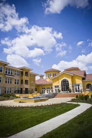 Exterior view of Health Services Center at Santa Marta, yellow multi-building facility with curved walkway.