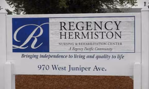 A large sign reads Regency Hermiston Nursing & Rehabilitation Center with address on a white panel.