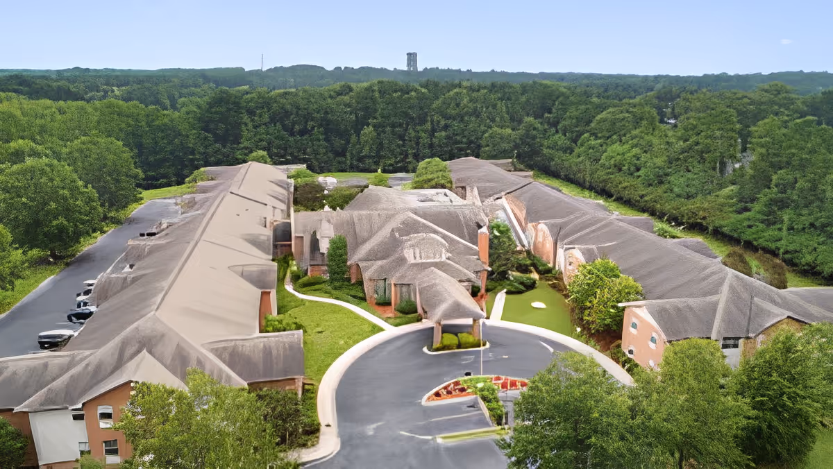 Aerial view of TerraBella Windsor Lake facility surrounded by dense green trees. The building has multiple wings with a circular driveway and landscaped greenery in the front.