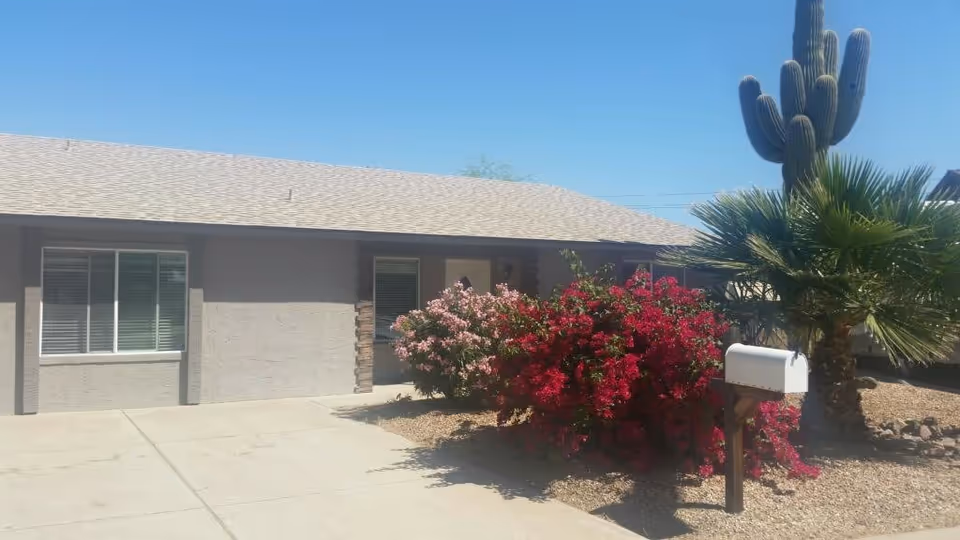 Front exterior of Joyful Haven assisted living home with desert landscaping and mailbox.