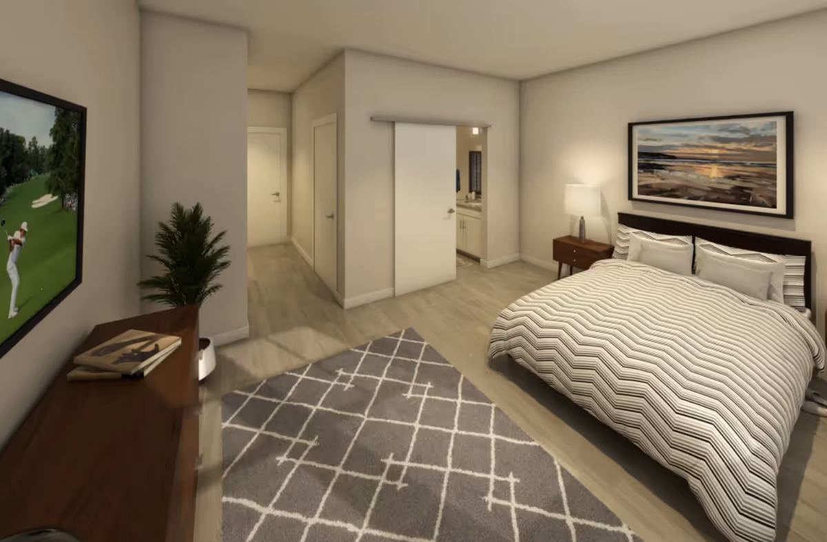 A modern bedroom with a large bed covered in a striped comforter, a nightstand with a lamp, a framed landscape picture on the wall, a patterned area rug on the floor, a wooden dresser with books and a potted plant, and a wall-mounted TV showing a golf game. There is a hallway with two doors and a sliding door leading to a bathroom.