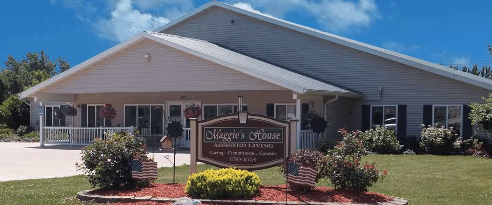 Exterior view of Maggie's House Assisted Living facility with a well-maintained garden.