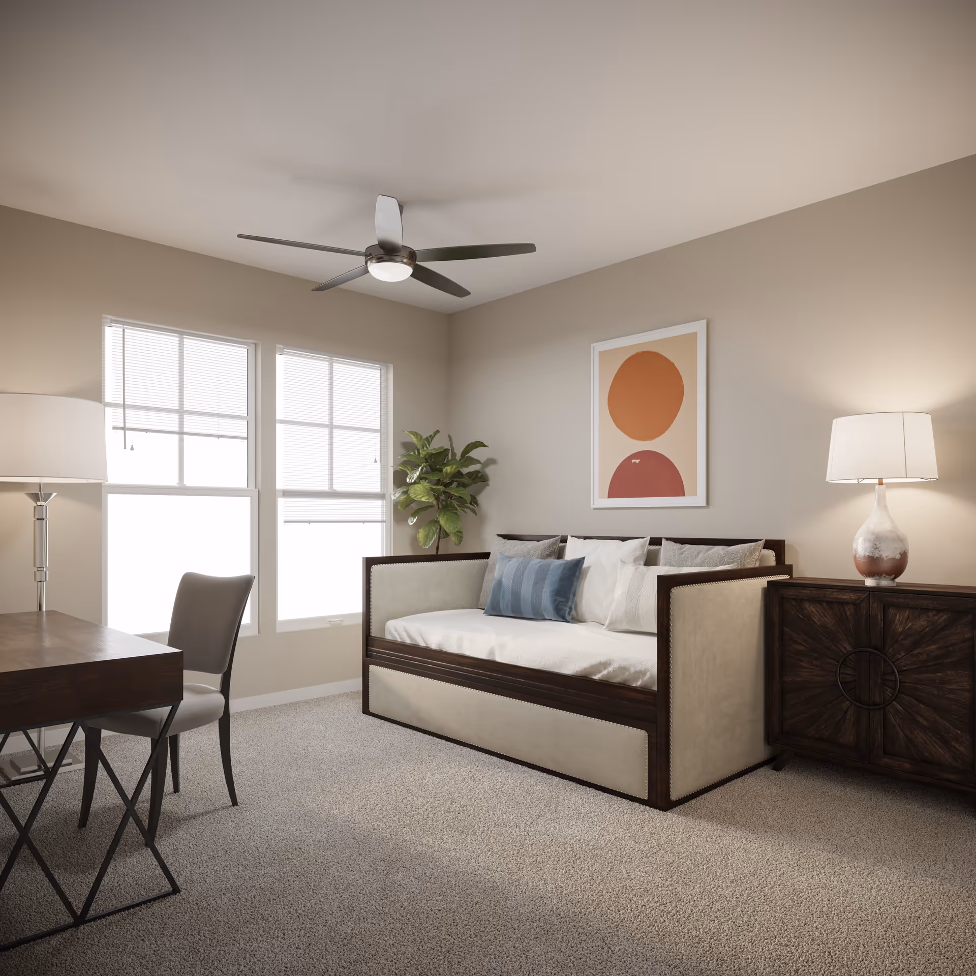 Bright furnished living room featuring a daybed with pillows, a desk and chair, lamps, framed art, and a ceiling fan.
