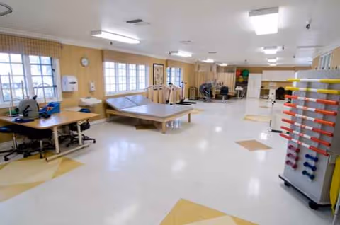 Bright therapy room with equipment, tables, and exercise stations inside Canyon Oaks Nursing and Rehabilitation Center