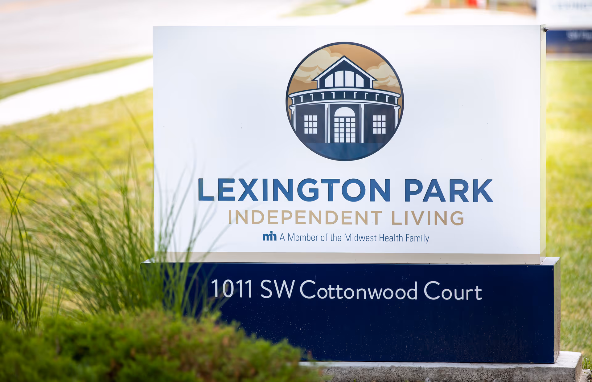 A freestanding outdoor sign on grass that reads "Lexington Park Independent Living" with the address 1011 SW Cottonwood Court.
