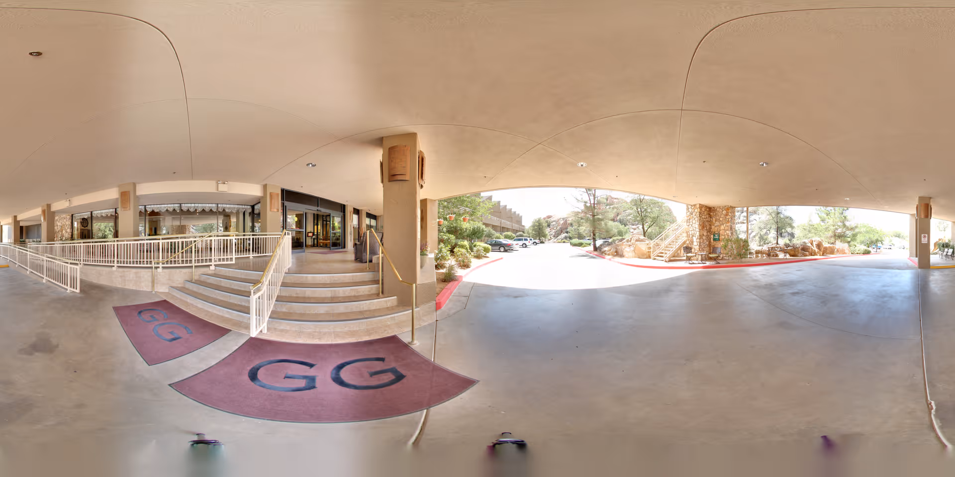 Covered porte-cochere entrance with steps, wheelchair ramp, two maroon doormats marked 'GG', and a driveway with landscaping.