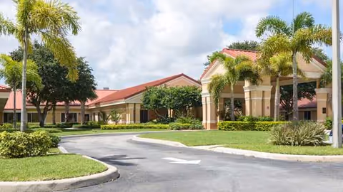 Exterior view of Boca Circle Rehabilitation Center with palm trees, driveway, and entrance archways.