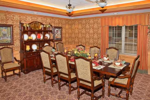 Formal dining room with a long table set for a meal and china cabinet.