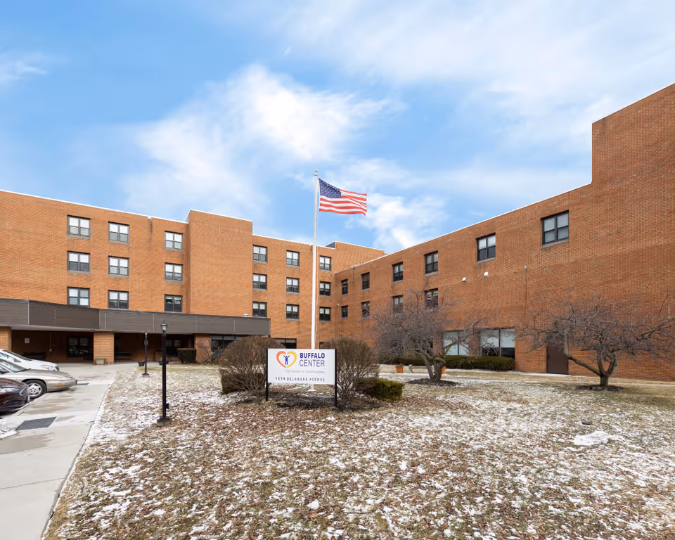 Brick Buffalo Center for Rehabilitation and Nursing exterior with flag, sign, and snow.