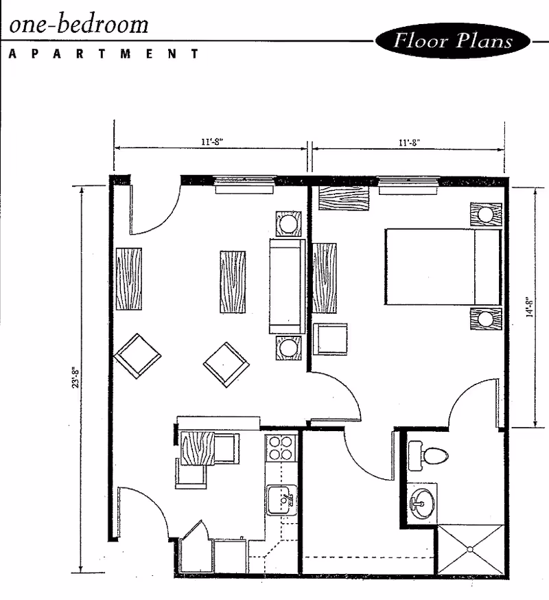 Black and white floor plan of a one-bedroom apartment showing a living room with furniture, a kitchen area with appliances, a bedroom with a bed and nightstands, and a bathroom with a toilet, sink, and shower.