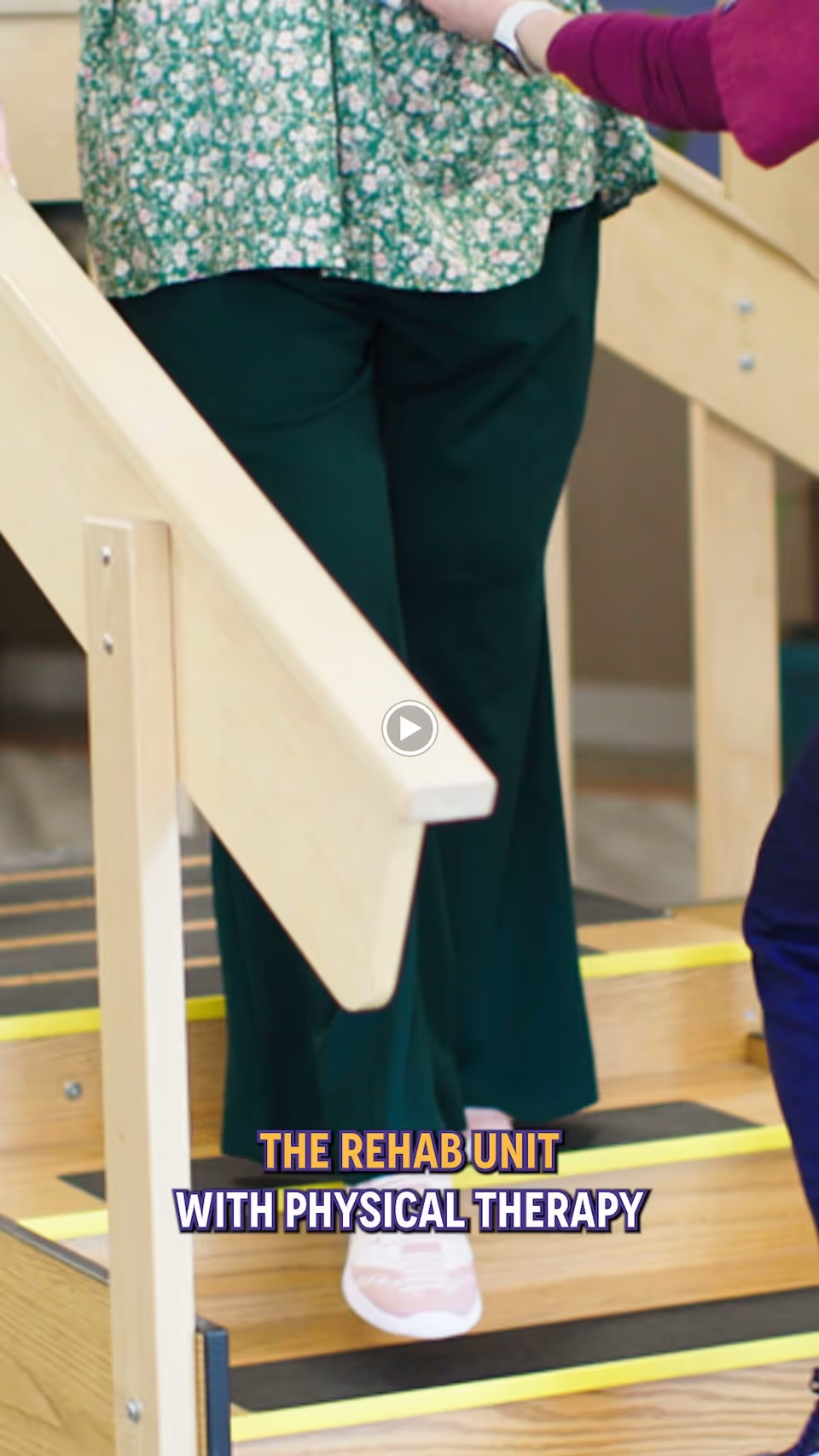 A person wearing green pants and pink shoes is walking up wooden stairs with handrails, assisted by another person whose arm is visible. Text on the image reads 'THE REHAB UNIT WITH PHYSICAL THERAPY'.