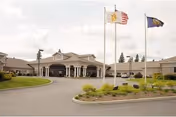 Exterior view of Life Care Center of Coeur d'Alene entrance with flagpoles.