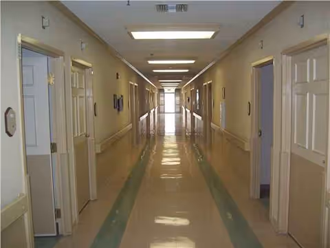 Interior corridor of a senior living facility with doors on both sides.