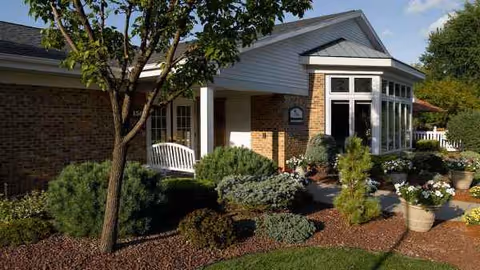 Front view of The Village at Towngate building with landscaped entrance and porch seating.