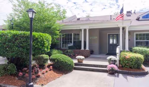 Front view of Farmington Square Beaverton entrance with landscaping and flag