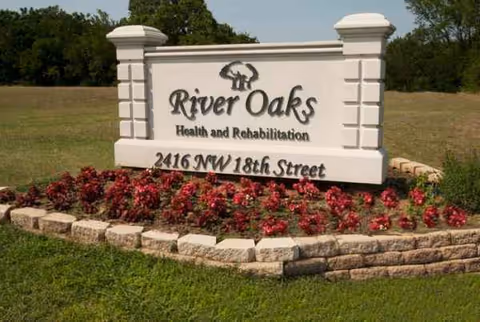 Exterior sign for River Oaks Health and Rehabilitation surrounded by flowering bed