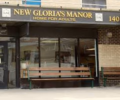 Front exterior of New Gloria's Manor Home for Adults with a bench outside.
