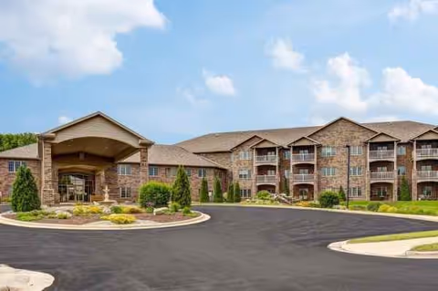 Exterior view of Brookview Meadows, a brick senior living facility with a curved driveway and entrance.