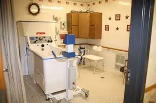 Utility room with a white medical hoist, cabinets, and star decor on walls.