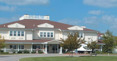 Front view of River Pointe Health Campus, a two-story beige building with a red roof.