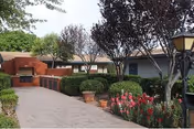 Outdoor courtyard at Westpark Wickenburg with walkway, planters, trees, and building in background.