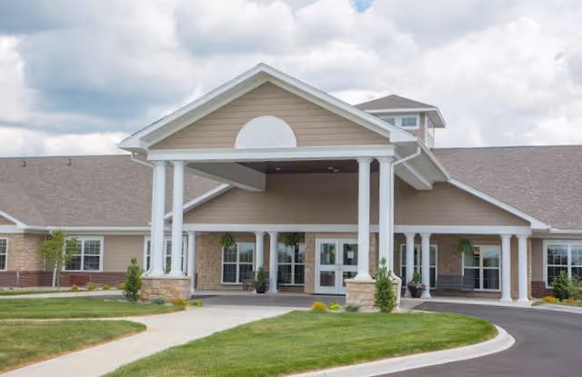 Front entrance of Sanders Ridge Health Campus showing a covered porte-cochère with white columns, glass doors, and a landscaped driveway.