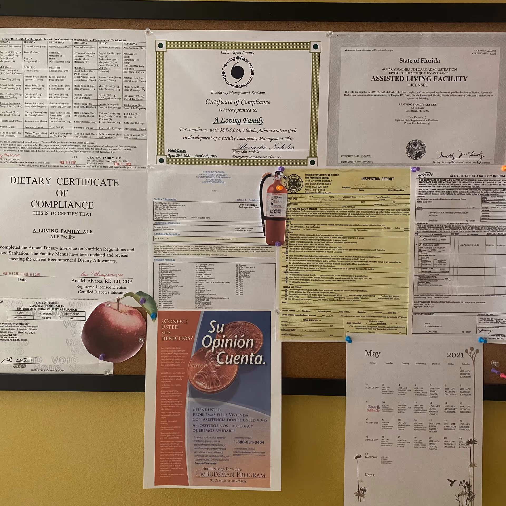 A cork bulletin board inside A Loving Family ALF displaying certificates, inspection reports, a calendar and a Spanish flyer titled 'Su Opinión Cuenta.'