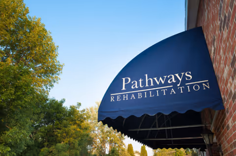 Blue awning reads Pathways Rehabilitation extending from a brick building exterior.