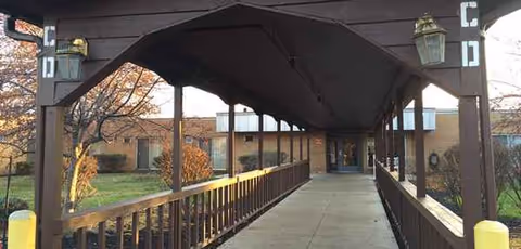 Covered outdoor ramp leads to the facility entrance with wooden railings.