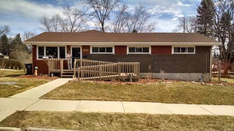 Single-story brick senior living facility with ramp and small front porch.