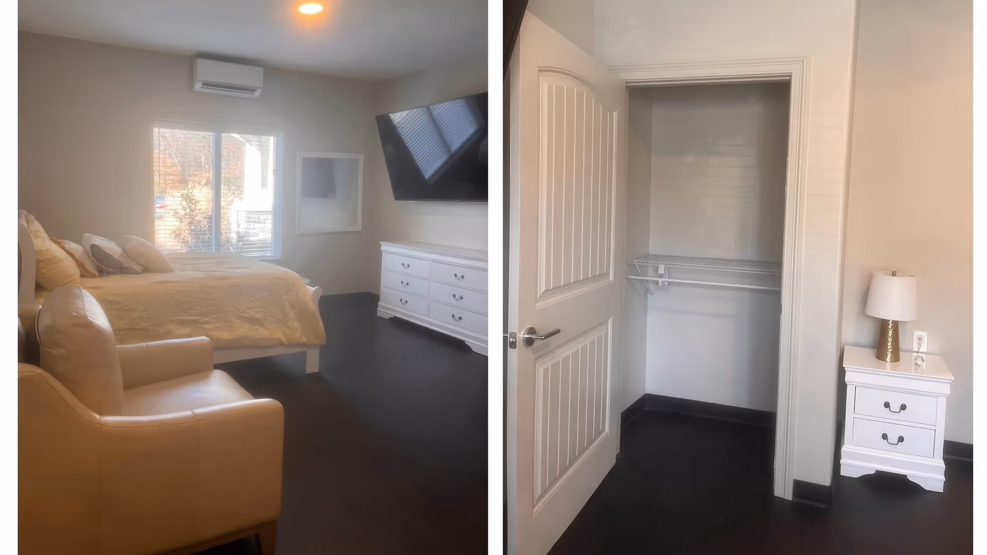 A bedroom with a beige armchair, a bed with yellow bedding and multiple pillows, a large window with blinds, a wall-mounted TV above a white dresser, and an open closet with a white door and wire shelving. A white nightstand with a gold and white lamp is next to the closet.