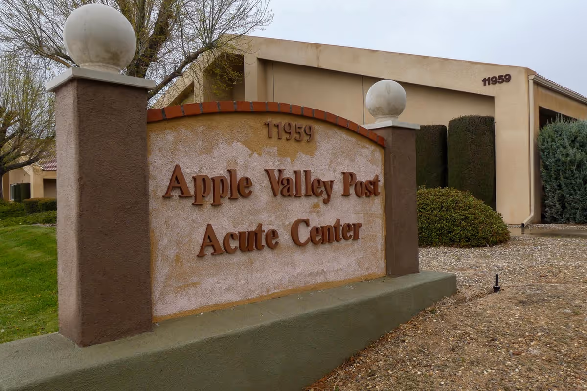 Entrance sign reading "Apple Valley Post Acute Center" with the beige facility building and address 11959 visible behind it.
