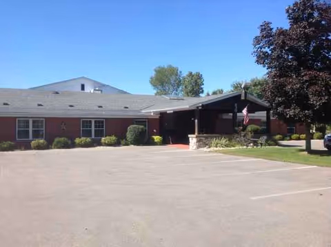 Front exterior of a single-story brick senior living facility with a covered entrance.
