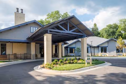 Senior living facility exterior with a covered entrance and landscaped driveway.