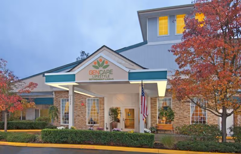 Front view of GenCare Lifestyle Lynnwood entrance with flag and autumn trees