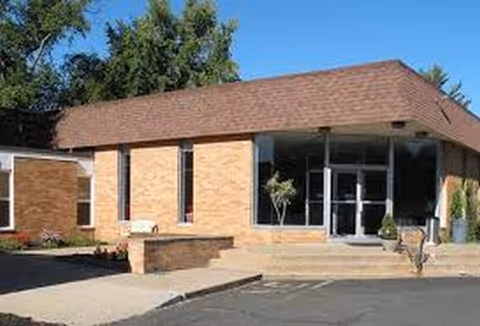 Exterior view of Ambler Extended Care Center entrance with brick facade and glass doors.