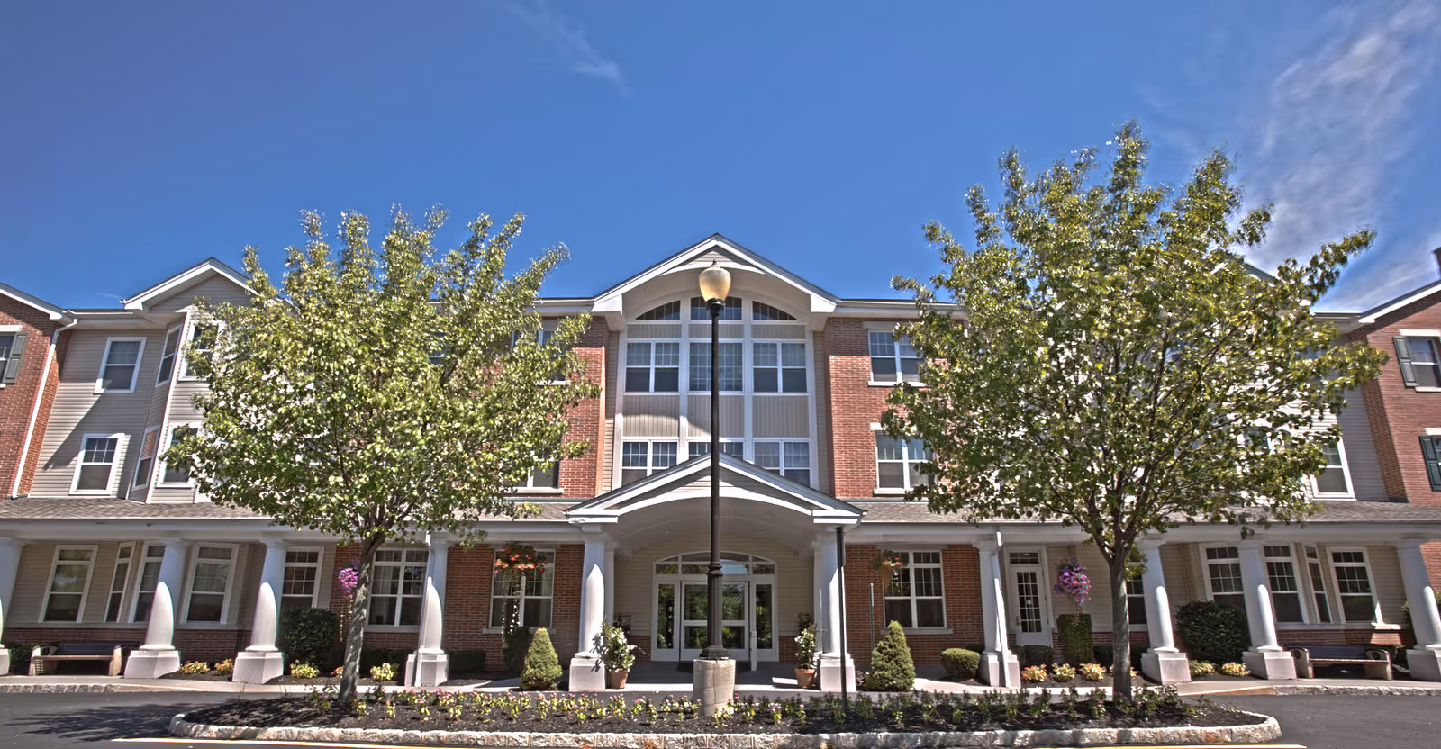 Exterior view of Brandywine The Sycamore by Monarch building with trees and entryway.