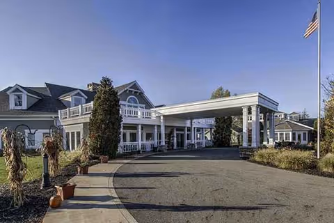 Exterior view of Maplewood at Chardon entrance with porte-cochère and flag.