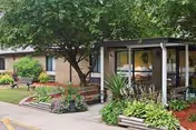 Exterior view of Teays Valley Center with a covered porch, greenery, and benches.