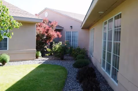 Exterior view of Cedar Ridge facility featuring beige walls, large windows, and a landscaped courtyard.