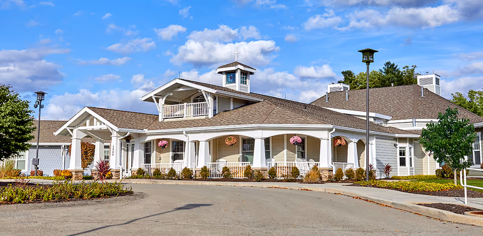 Exterior view of Rosecrest Residence senior living facility with front porch and landscaping.