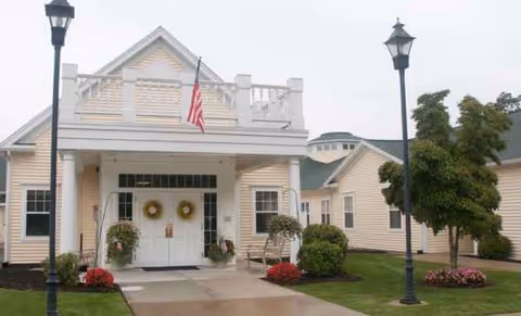 Exterior view of The Atrium at Veronica Drive entrance with wreaths, flag, and lampposts.