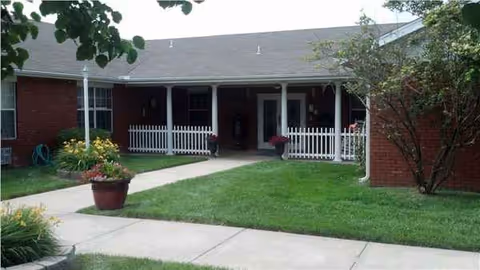 Single-story brick building with a covered front porch and manicured lawn at Hartville Care Center.
