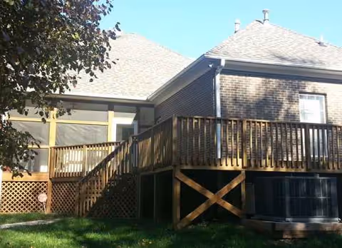 Exterior view of Gracie Strudivant Care Home featuring brick walls, a wooden deck, and stairs.