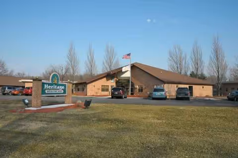 Heritage Healthcare building with sign, flag, and parking lot in front.