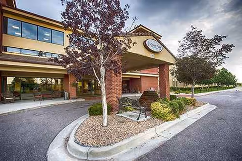 Exterior view of Lowry Park senior living entrance with benches and landscaped island.