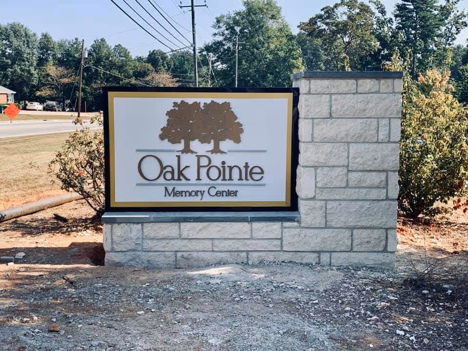 Oak Pointe Memory Center sign on a stone pedestal beside a road.